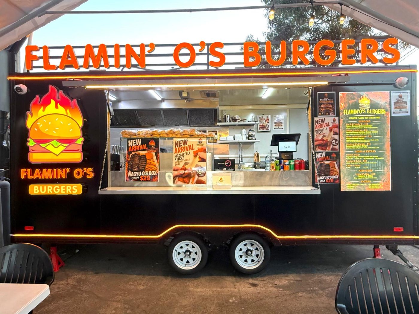 Flamin O's Burgers food trailer with menu board and neon signage